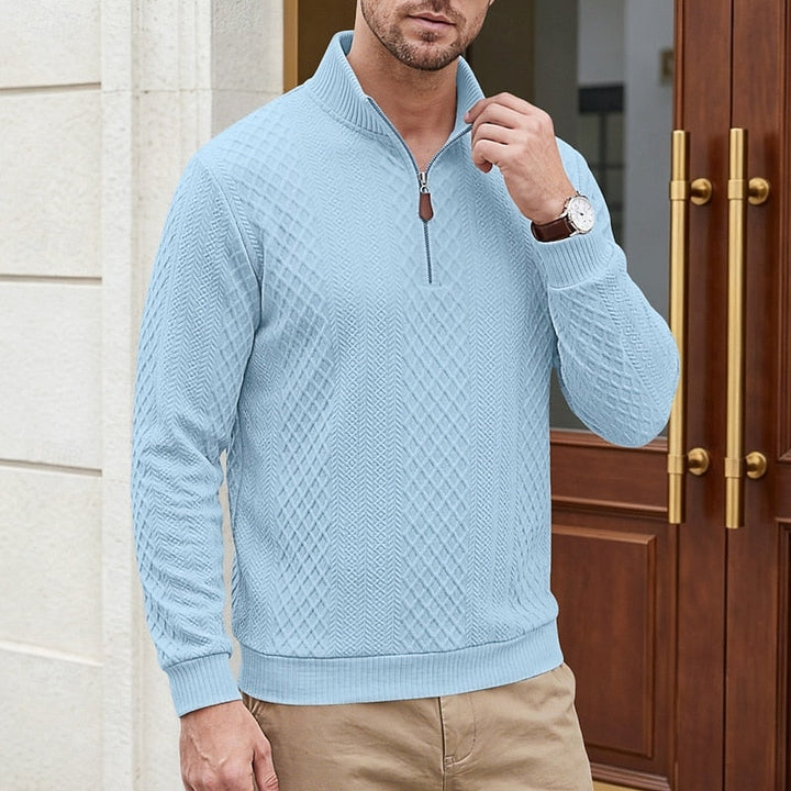 Man wearing Bennett light blue textured quarter-zip pullover near a doorway, close-up front view