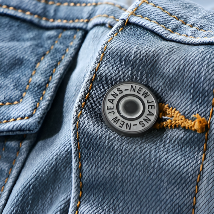 Close-up of dark snap button rivet detail on denim jacket