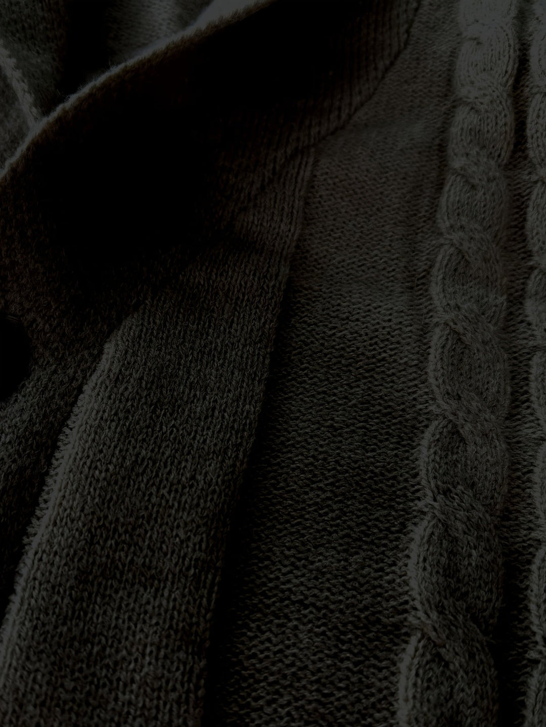 Close-up of black cable knit fabric texture