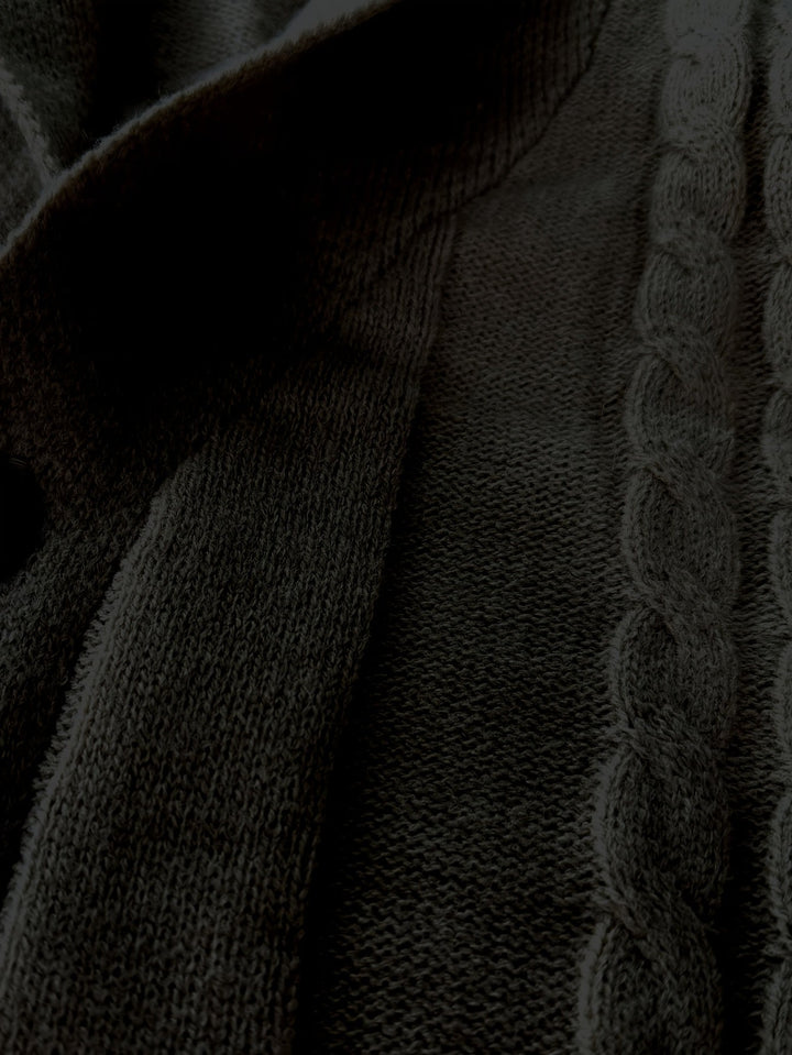 Close-up of black cable knit fabric texture